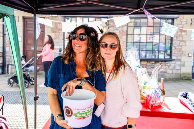 Two women at a Big Lunch with donation bucket