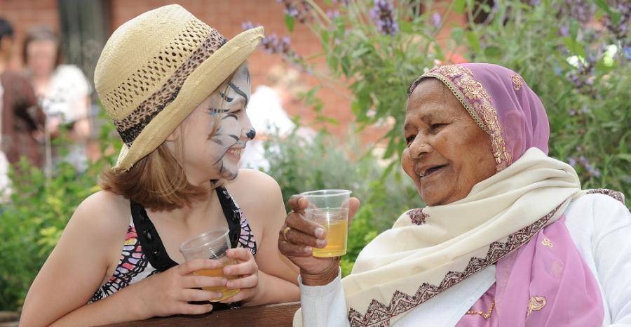 Older lady talking to a young girl with her face painted