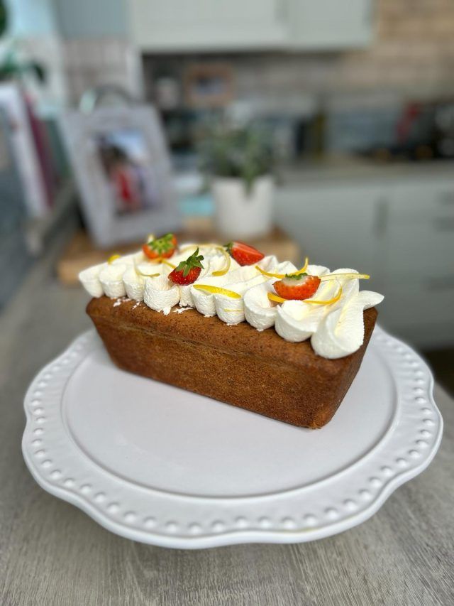 Lemon and poppy seed loaf with piped mascarpone cream and garnish.