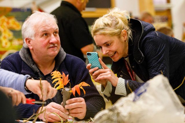 Person taking a photograph of a craft project