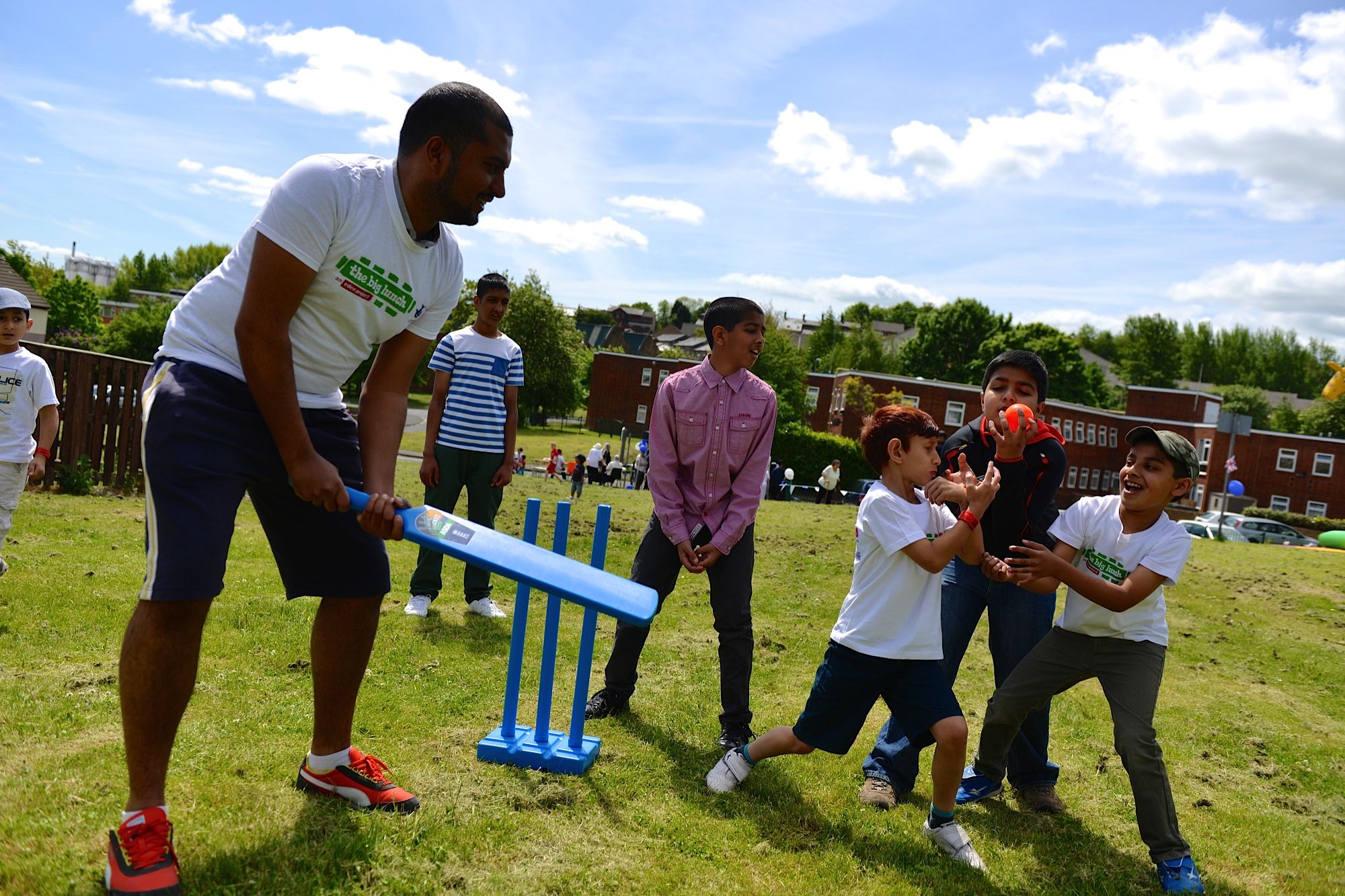 Photo of adults and children enjoying outdoor games in a community space