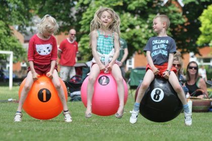 Three children bouncing on hoppers