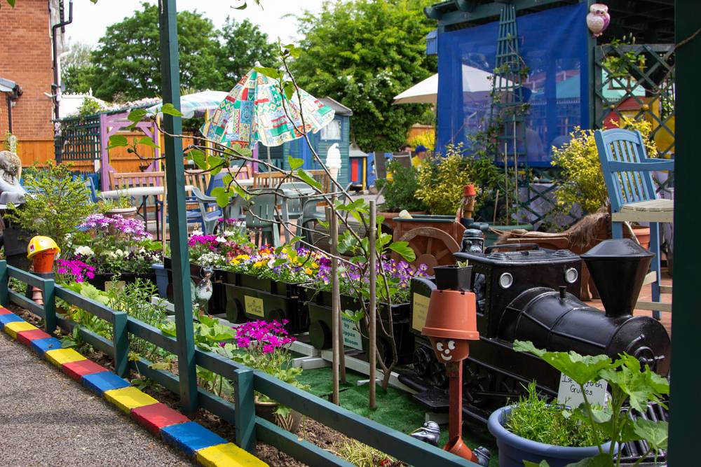 A community garden with a model train set with planters as carriages