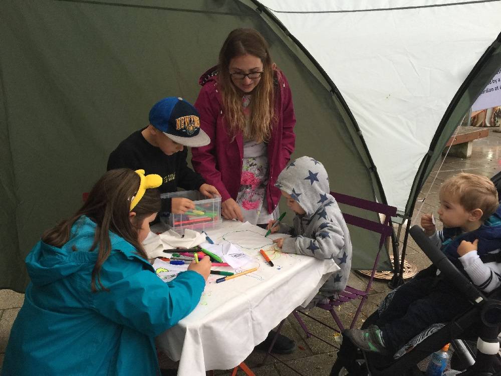 Children painting on a tablecloth