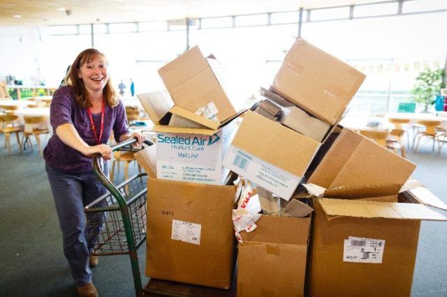 Woman pushing trolley with cardboard box