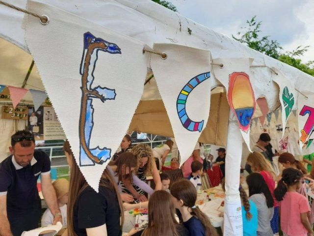 A bunting making event in a tent with eco written on the bunting outside