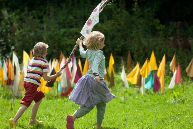 Children playing outside with a flag