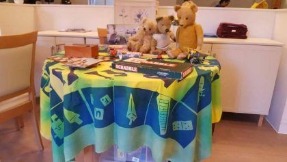 Teddybears sat on top of a decorated tablecloth