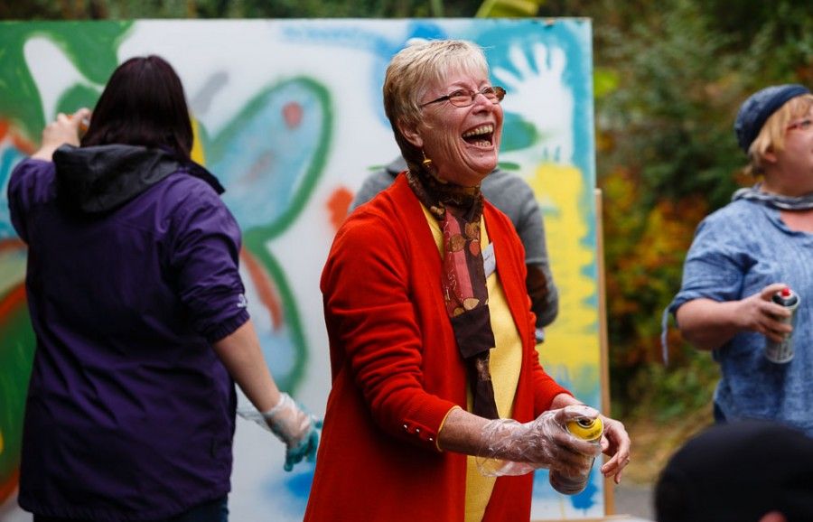 Elderly woman holding can of spray paint