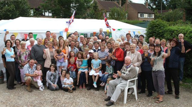 Large group of people posing outside gazebo for photo after Jubilee Lunch