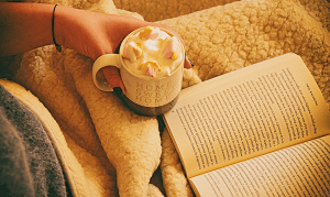 Reading a book with a hot drink