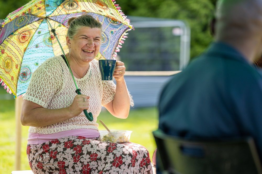 Woman drinking tea holding an umbrella