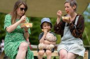 People sitting on bench eating food