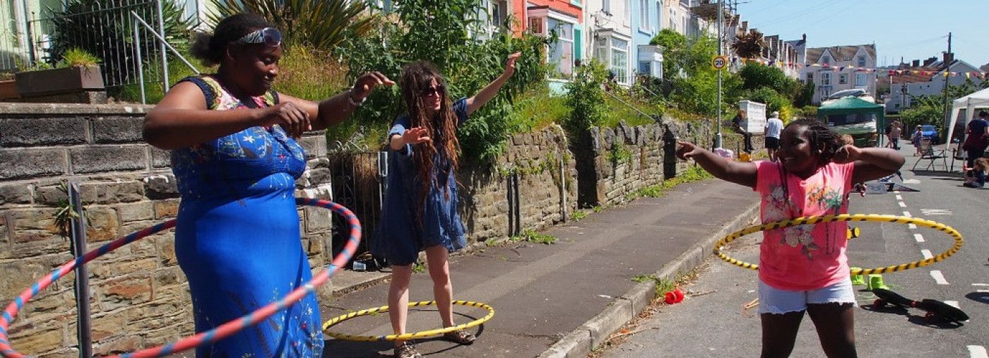 3 people hula hooping in the street