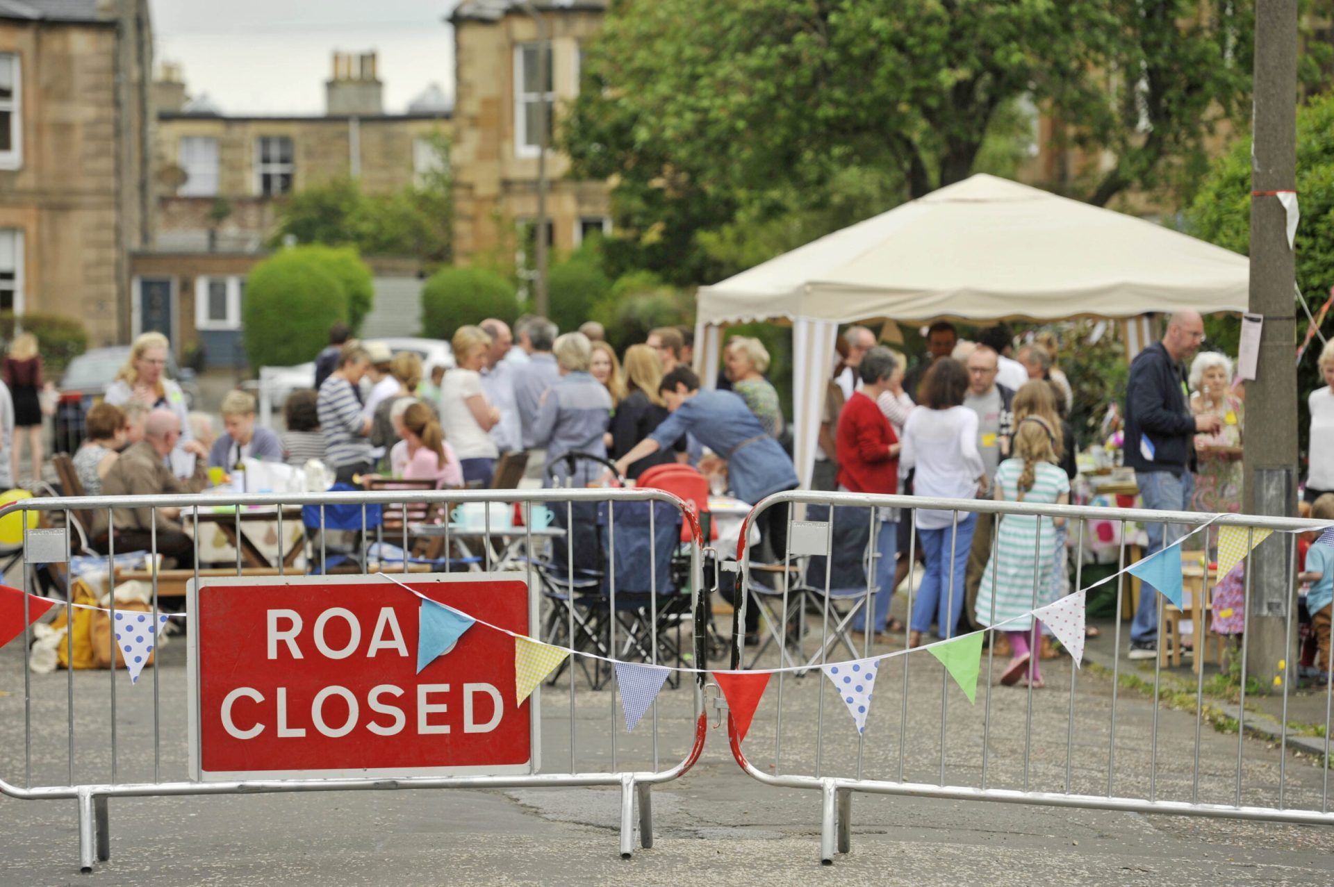 Road closed sign with big lunch party in the background