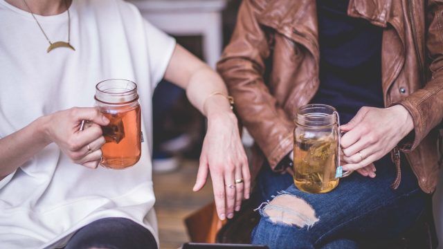 Two people holding a hot drink