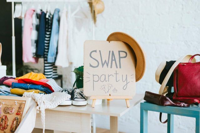 Swap party sign with racks of clothing visible in background