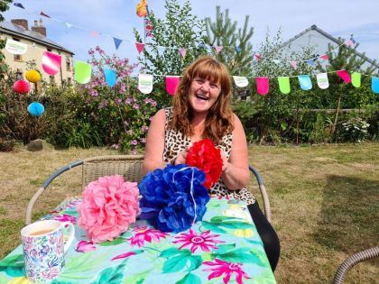 Woman in garden making paper pom poms