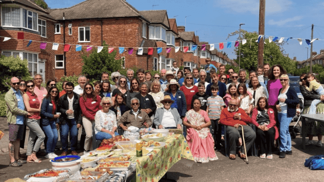 Group standing in street under bunting on a sunny day