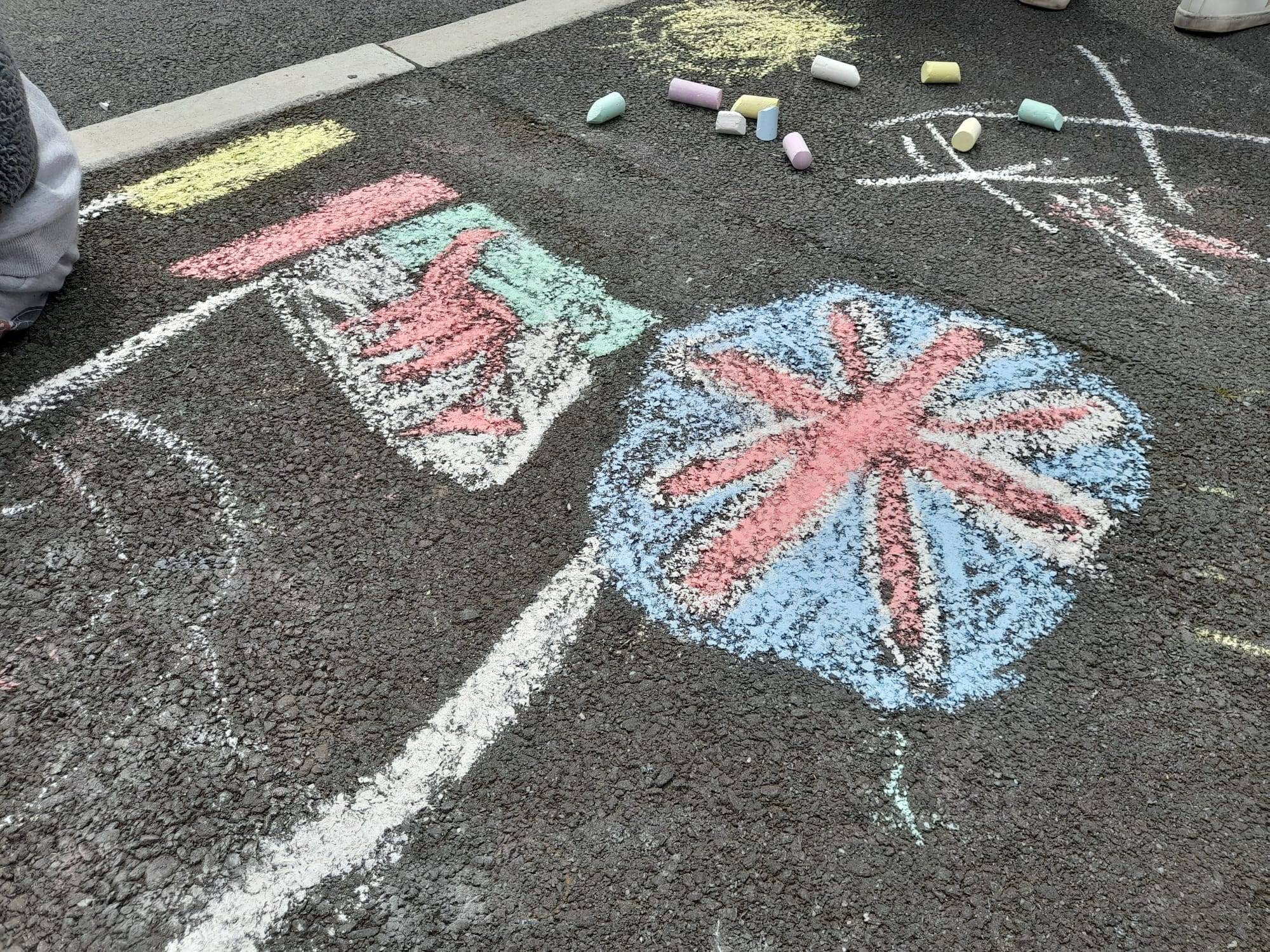 A Union Jack and Welsh flag drawn in chalk on the pavement