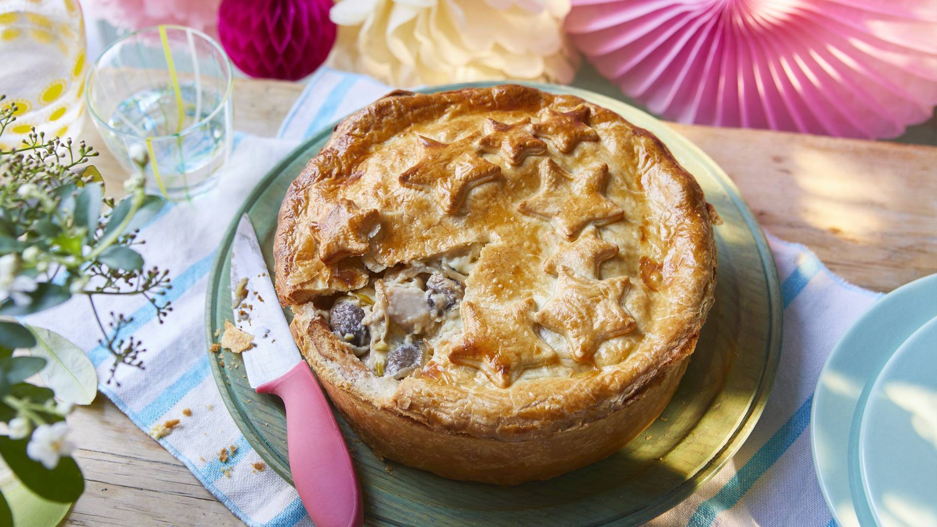 The winning Coronation Dish, a flaky pastry pie, a slice is cut out and the filling is chicken, leeks and mushrooms in a creamy sauce. Pastry stars decorate the top.