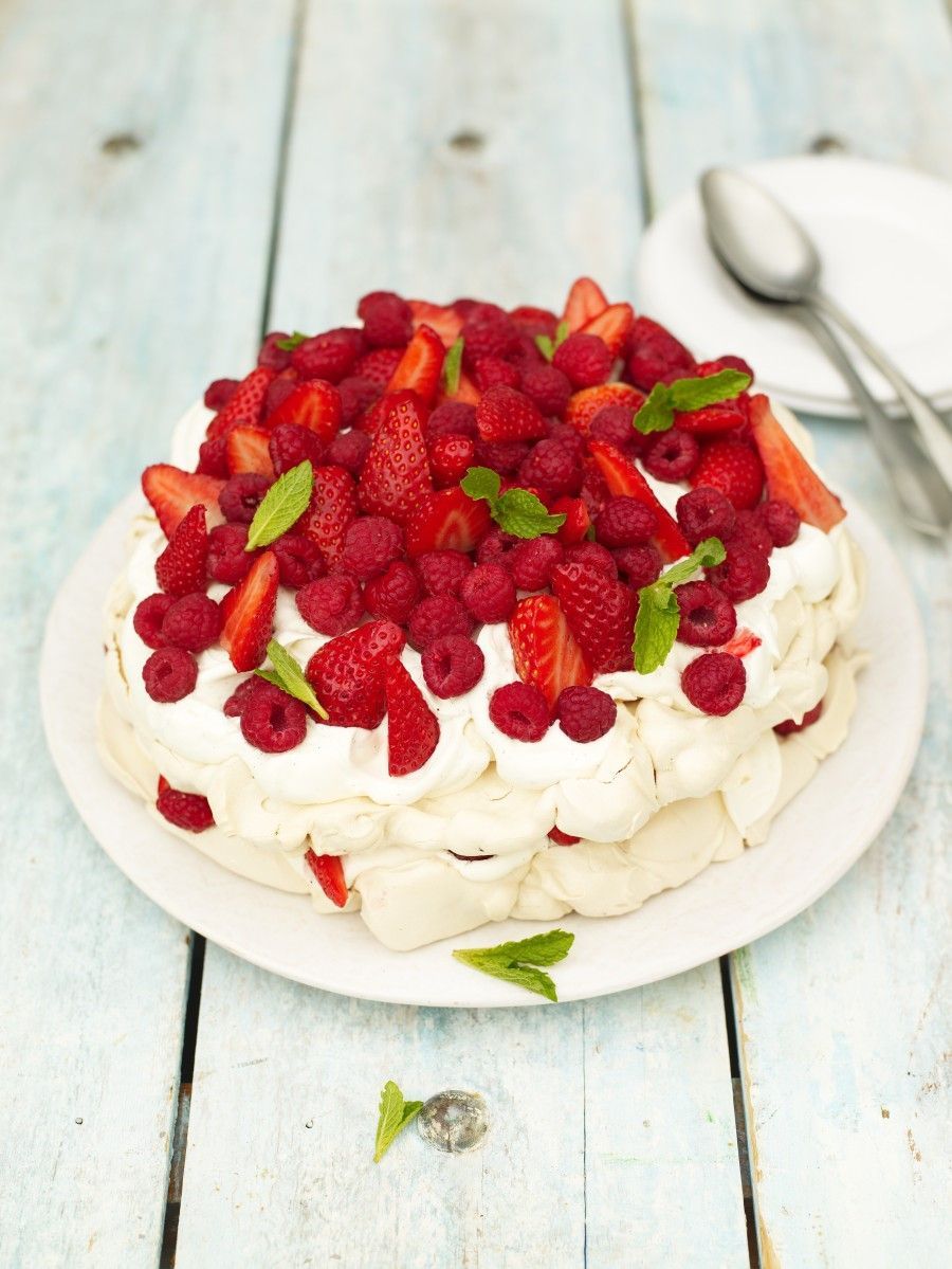 Pavlova piled with strawberries, raspberries and mint