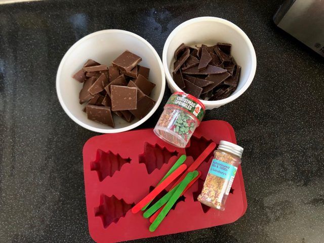 Silicone mould in Christmas tree shape and chocolate in bowls