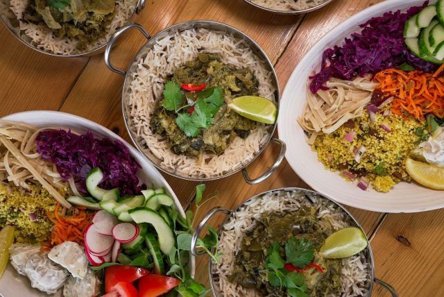 Thai green curry with rice in a bowl, with delicious ingredients surrounding it