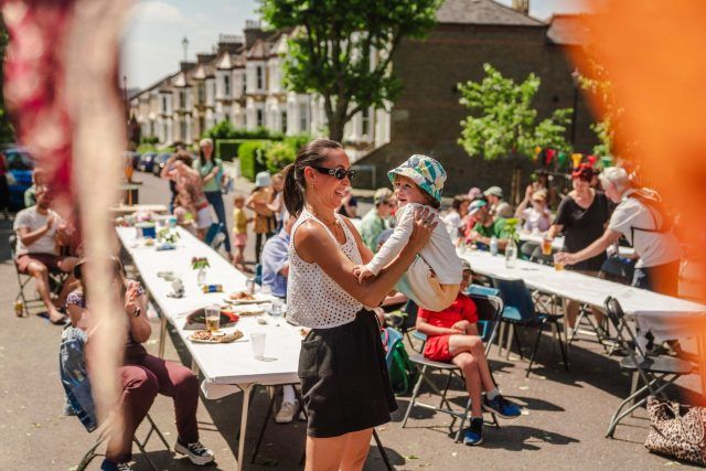 Woman dancing with her baby at a street party community Big Lunch