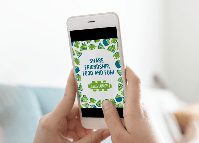 The Big Lunch social media graphic on a phone in a person's hand