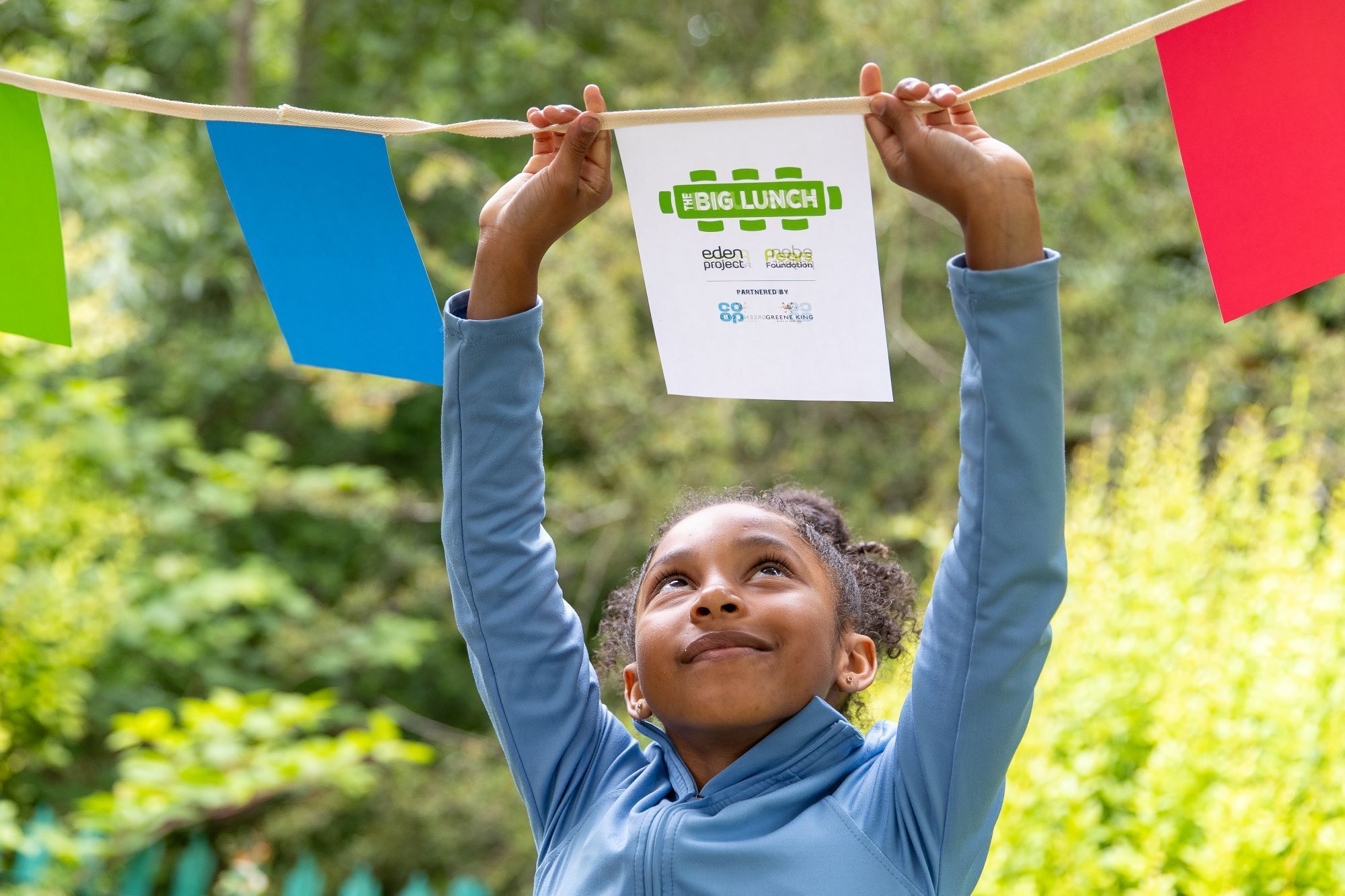 Child rearranges bunting at The Brandwood Centre, Birmingham