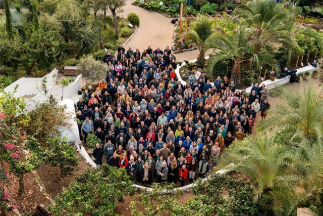 A big group of all the Eden Project staff stand in the Mediterranean Biome. The photo is taken from above.